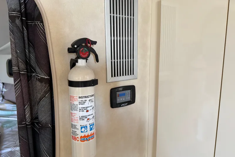 Slide: The Image of Fire extinguisher and control panel inside 1990 Silverton 34 Express boat cabin. - 23