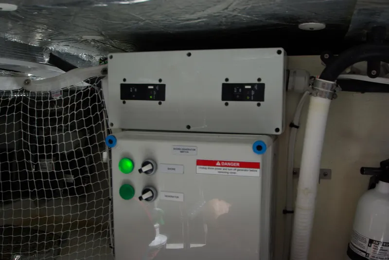 Slide: The Image of A control box with switches and lights in a boat, surrounded by nets and pipes. - 60