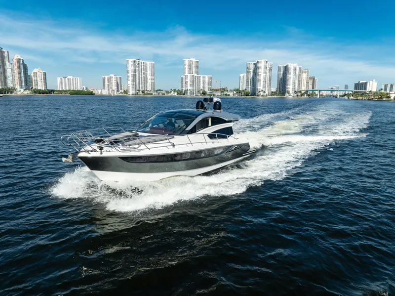 Slide: The Image of 2016 Galeon 430 HTC yacht cruising on a sunny day near city skyline. - 4