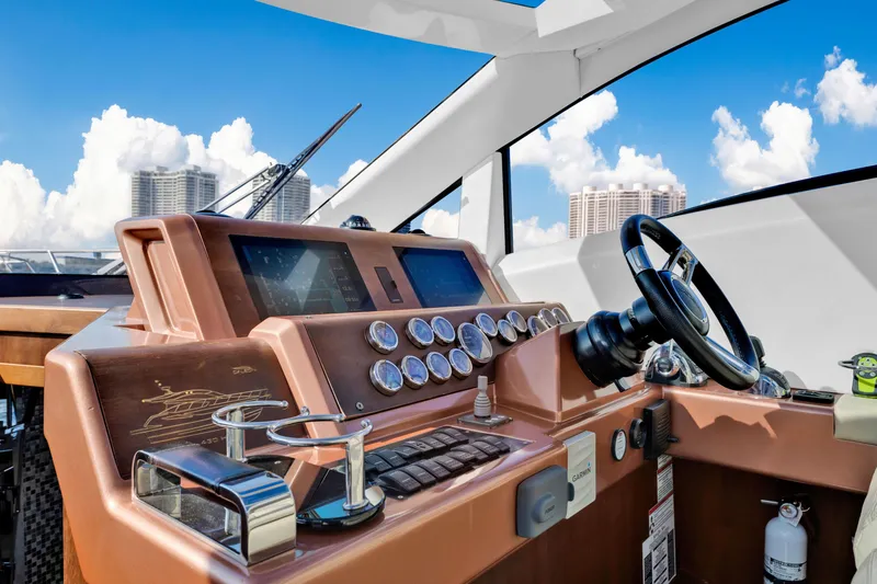 Slide: The Image of Galeon 430 HTC 2016 yacht helm with modern controls and city skyline backdrop. - 16