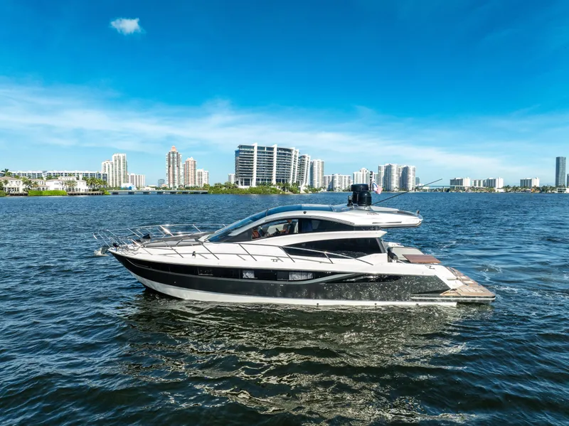 Slide: The Image of Galeon 430 HTC 2016 yacht cruising on a sunny day with city skyline backdrop. - 1