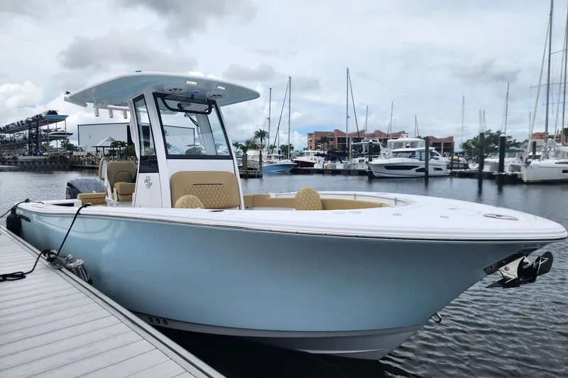 The Image of 2024 Sportsman Open 232 Center Console boat docked at marina, showcasing sleek design. - 0