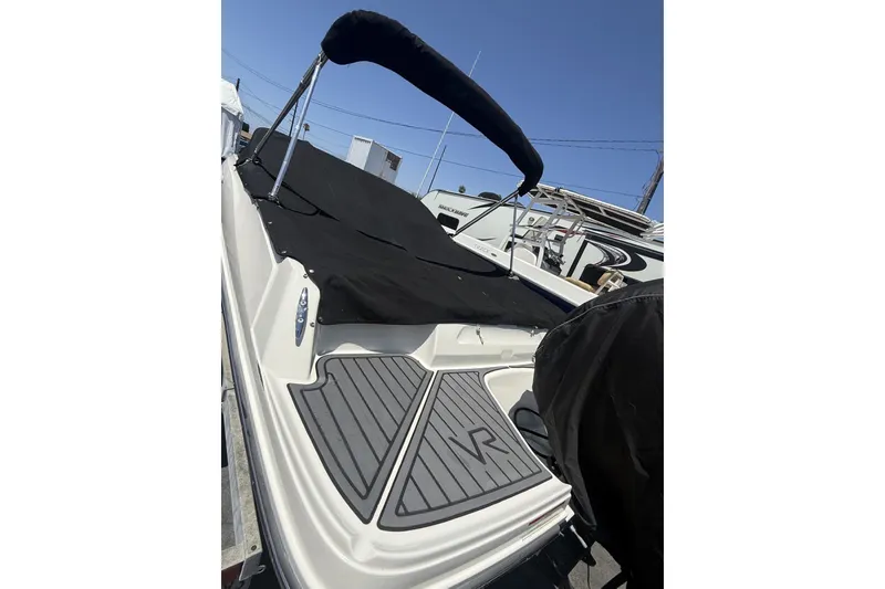 Slide: The Image of 2023 Bayliner VR4 Bowrider I/O with black cover and sleek design. - 5