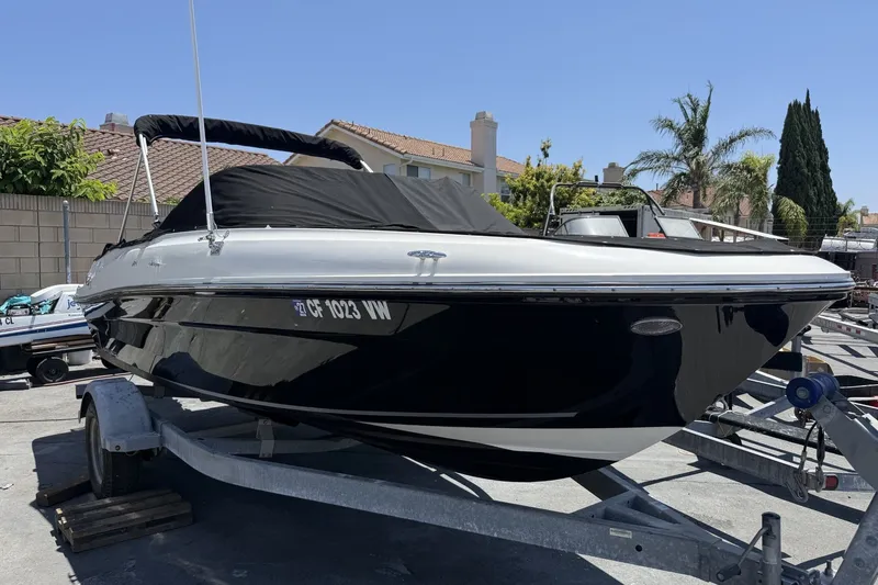 The Image of 2023 Bayliner VR4 Bowrider I/O on trailer, covered, in sunny residential area. - 1