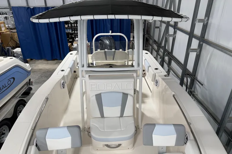 Slide: The Image of 2026 Robalo R200 Center Console boat with T-top in a showroom. - 8