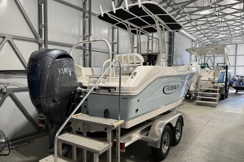 Slide: The Image of 2026 Robalo R200 Center Console boat with Yamaha engine in a storage facility. - 1