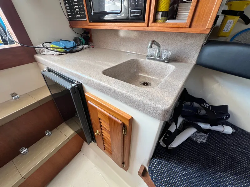 Slide: The Image of The galley of a 2002 Albemarle 280 Express Fisherman with sink, fridge, and microwave. - 14