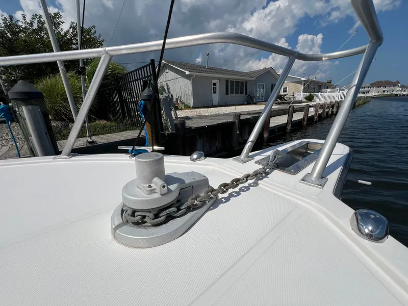 Slide: The Image of The image shows the bow deck of a 2002 Albemarle 280 Express Fisherman, docked by a pier. - 19