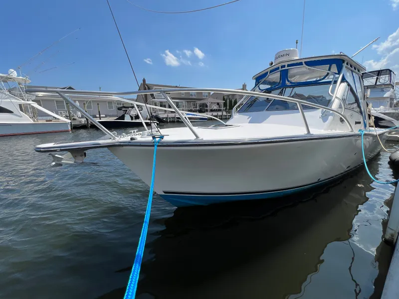 The Image of A 2002 Albemarle 280 Express Fisherman is docked. It features a blue rope and covered cockpit. - 2