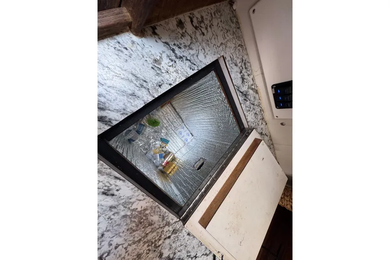 Slide: The Image of Refrigerator inside 1980 Morgan 382 yacht with marble countertop and open door. - 17