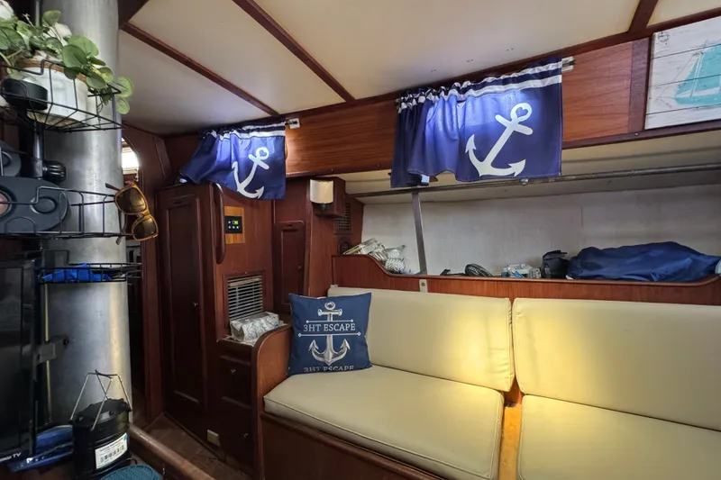 Slide: The Image of Interior of 1980 Morgan 382 sailboat with nautical-themed decor and anchor curtains. - 25