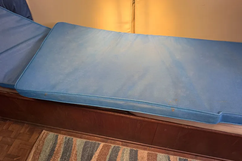 Slide: The Image of Blue cushion on a wooden bench inside a 1980 Morgan 382 sailboat. - 28