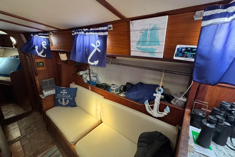 Slide: The Image of Interior of a 1980 Morgan 382 sailboat with nautical decor and anchor-themed curtains. - 23