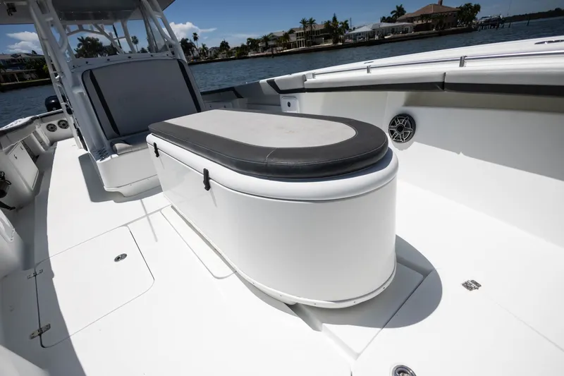 Slide: The Image of 2015 Yellowfin 39 Offshore boat interior with seating and storage, docked by waterfront homes. - 15