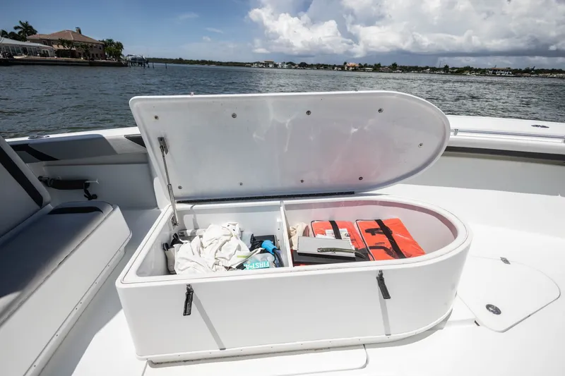 Slide: The Image of Open storage compartment on 2015 Yellowfin 39 Offshore boat, containing life jackets and gear. - 16