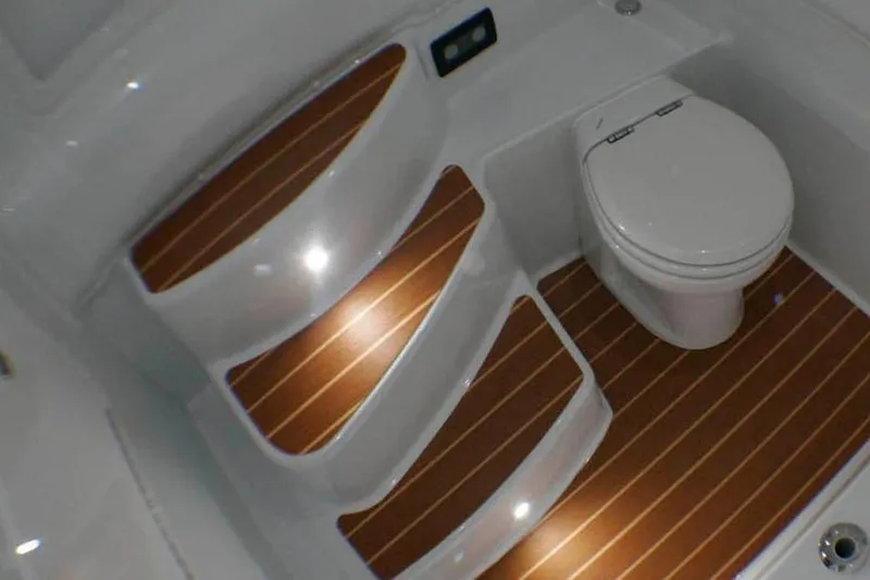 Slide: The Image of Manufacturer Provided Image: 2015 Yellowfin 39 boat bathroom with wooden steps and white toilet. - 28