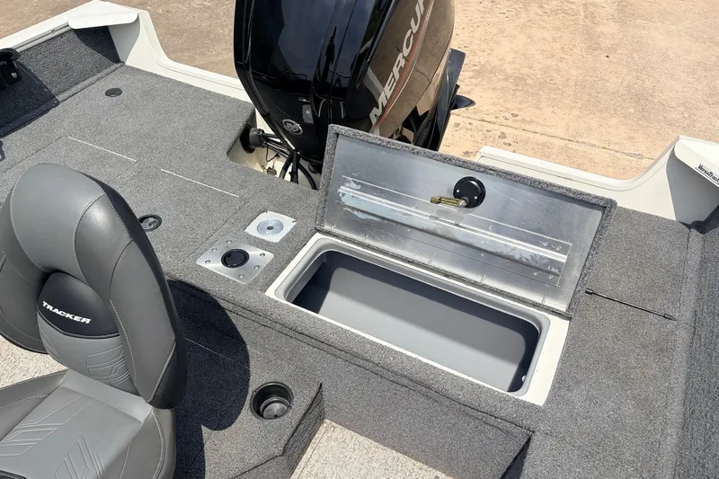 Slide: The Image of 2020 Tracker Pro Guide V-165 WT boat interior with open storage compartment and Mercury engine. - 24