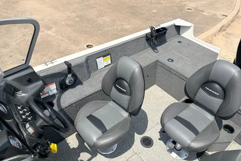 Slide: The Image of 2020 Tracker Pro Guide V-165 WT boat interior with two gray seats and steering console. - 29