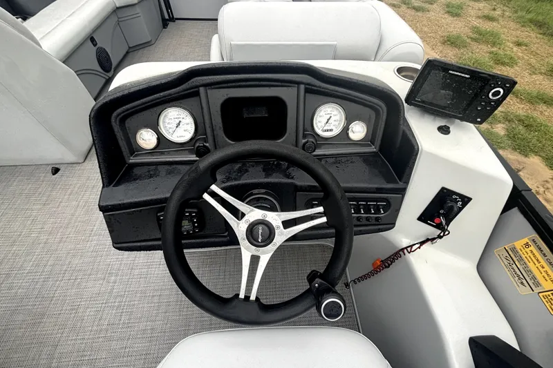 Slide: The Image of 2021 Bentley Pontoons 243 Navigator dashboard with steering wheel and gauges. - 11