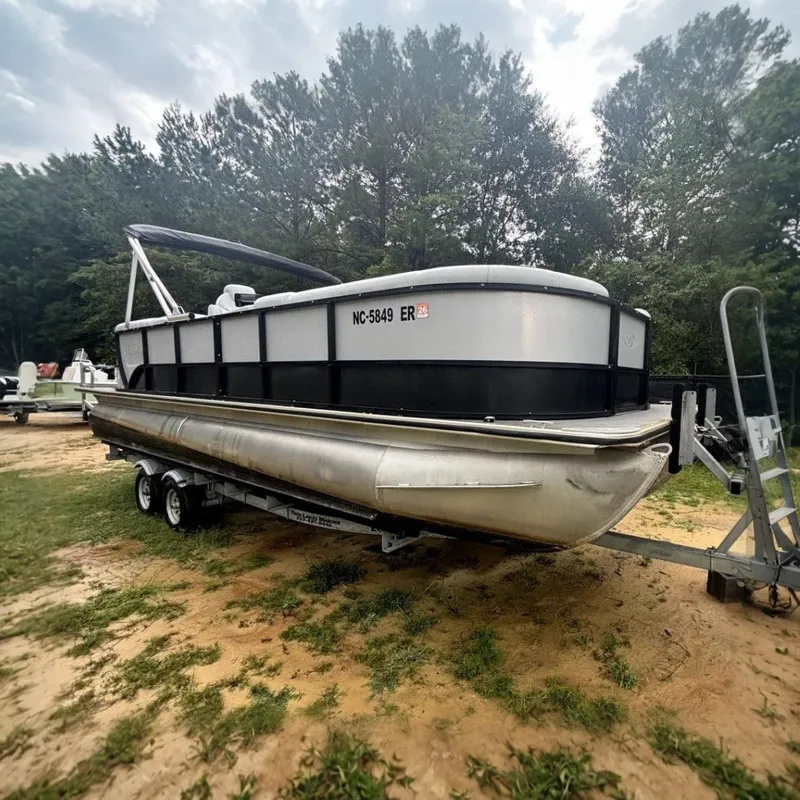 The Image of A 2021 Bentley Pontoons 243 Navigator on a trailer, surrounded by trees. - 0