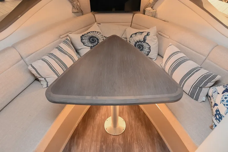 Slide: The Image of 2024 Sea Ray Sundancer 320 interior with cozy seating and decorative pillows. - 58