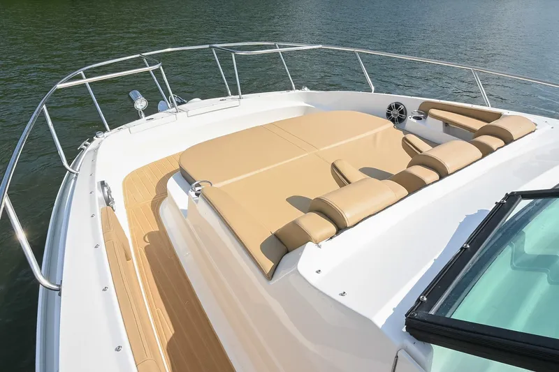 Slide: The Image of 2024 Sea Ray Sundancer 320 boat deck with tan seating, on calm water. - 24