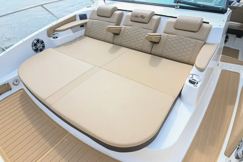 Slide: The Image of Luxurious seating on 2024 Sea Ray Sundancer 320 boat, featuring beige upholstery and cup holders. - 26