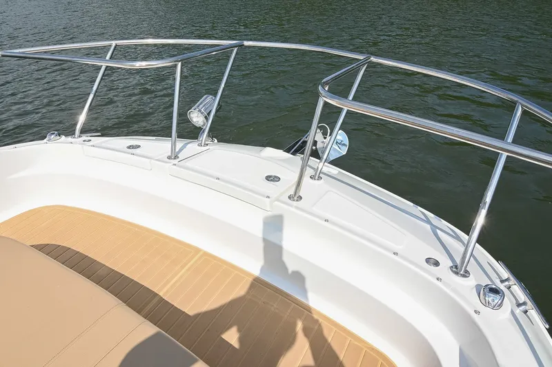 Slide: The Image of 2024 Sea Ray Sundancer 320 bow with stainless steel railings and teak deck, on calm water. - 50