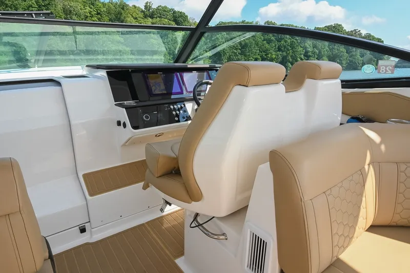 Slide: The Image of 2024 Sea Ray Sundancer 320 cockpit with beige seating and modern dashboard. - 32