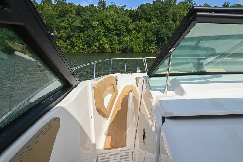 Slide: The Image of 2024 Sea Ray Sundancer 320 boat deck with scenic lake and forest backdrop. - 28
