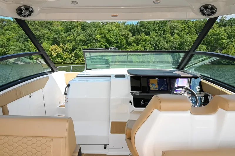 Slide: The Image of 2024 Sea Ray Sundancer 320 cockpit with modern dashboard and luxurious seating, overlooking serene waters. - 43