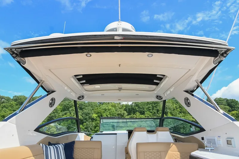 Slide: The Image of 2024 Sea Ray Sundancer 320 cockpit with luxurious seating and modern design under a clear blue sky. - 17