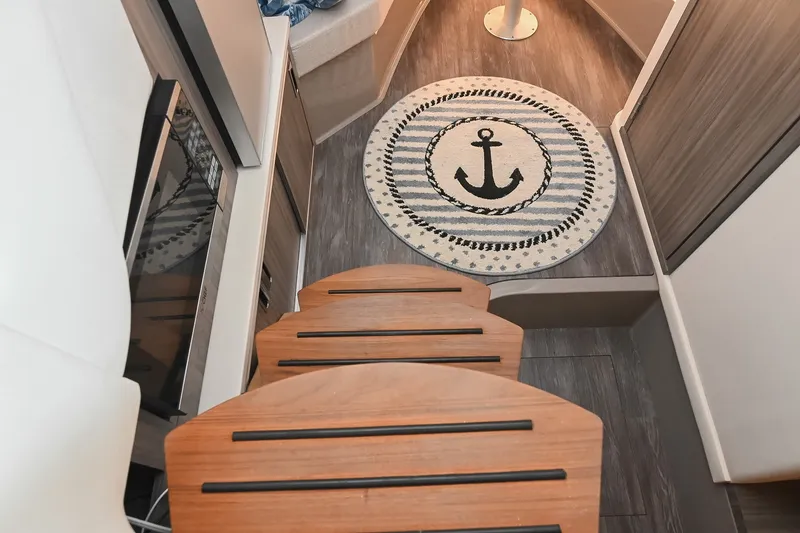 Slide: The Image of Interior of 2024 Sea Ray Sundancer 320 with nautical-themed decor and wooden steps. - 54