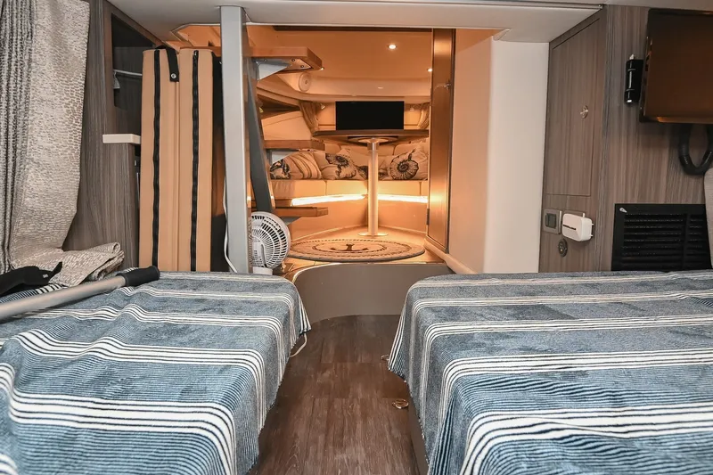 Slide: The Image of Interior of 2024 Sea Ray Sundancer 320 yacht, featuring cozy cabin with striped bedding. - 69