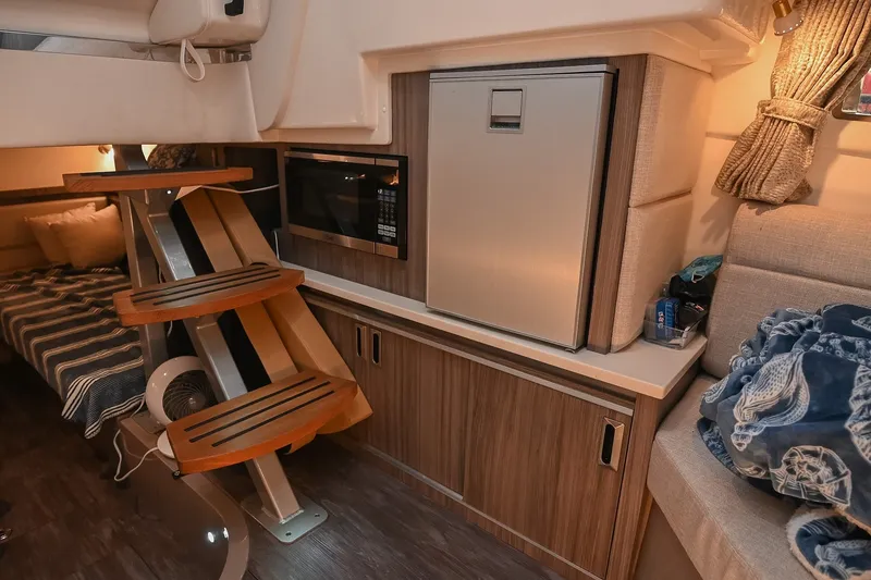Slide: The Image of 2024 Sea Ray Sundancer 320 interior with modern kitchenette and cozy seating area. - 62