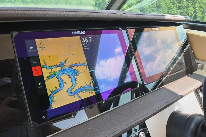 Slide: The Image of 2024 Sea Ray Sundancer 320 dashboard with Simrad navigation displays showing maps and data. - 36