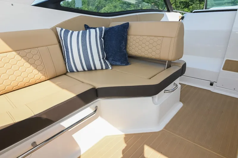 Slide: The Image of 2024 Sea Ray Sundancer 320 interior with tan seating and decorative pillows. - 20