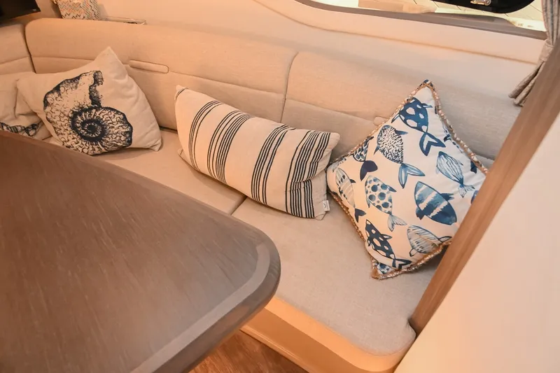 Slide: The Image of Interior of 2024 Sea Ray Sundancer 320 with decorative nautical-themed cushions. - 59