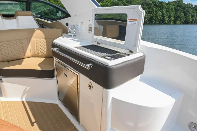 Slide: The Image of 2024 Sea Ray Sundancer 320 boat interior with seating and kitchenette by the water. - 39