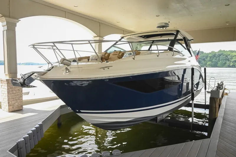 Slide: The Image of 2024 Sea Ray Sundancer 320 yacht docked in a covered marina, showcasing sleek design and luxury. - 77