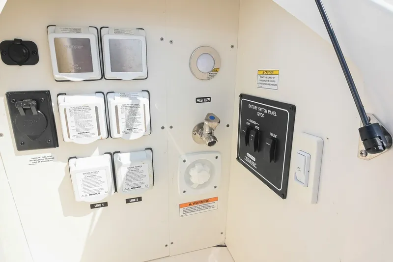 Slide: The Image of 2024 Sea Ray Sundancer 320 control panel with switches and power outlets. - 76