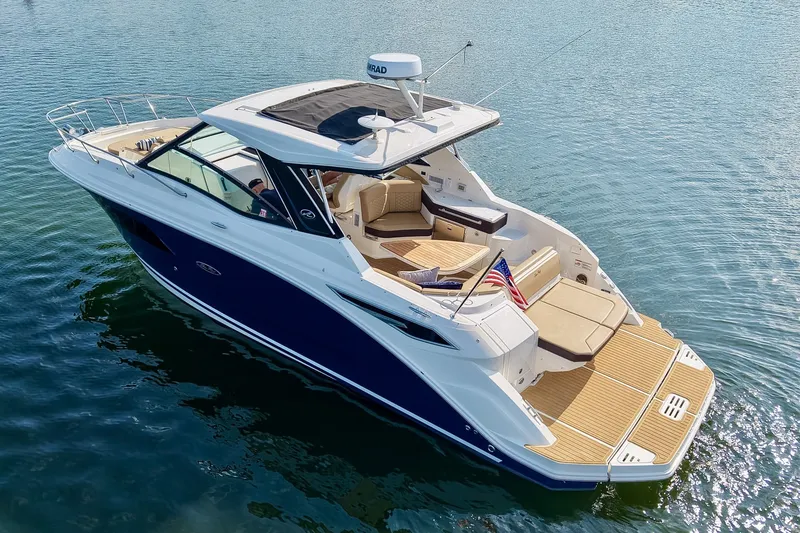 Slide: The Image of 2024 Sea Ray Sundancer 320 luxury yacht cruising on calm waters. - 13