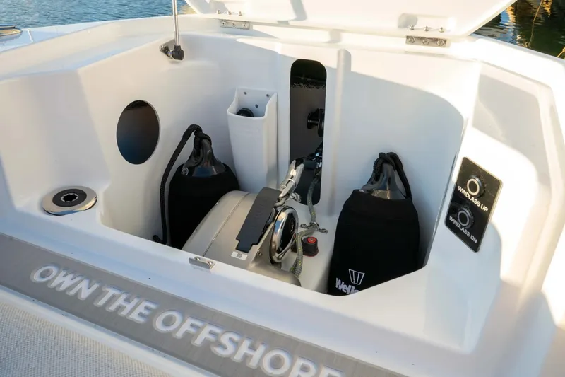Slide: The Image of 2027 Wellcraft 28 T-Top boat anchor storage with windlass controls and safety equipment. - 14