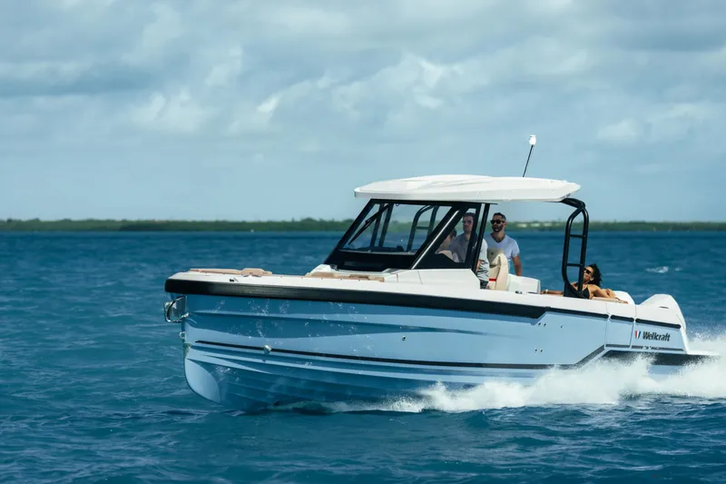 The Image of 2027 Wellcraft 28 T-Top boat cruising on open water under a cloudy sky. - 5