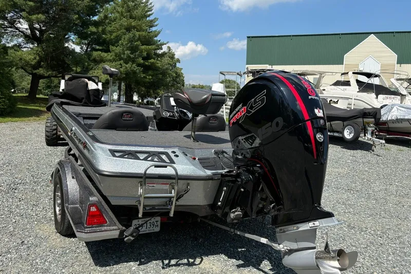 Slide: The Image of 2022 Ranger Z518 boat with powerful outboard motor, parked outdoors on gravel. - 7