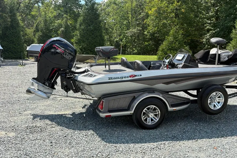 Slide: The Image of 2022 Ranger Z518 boat with Mercury Pro XS engine on a gravel lot. - 2