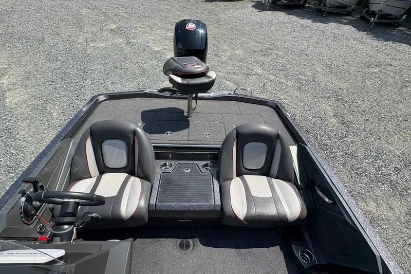 Slide: The Image of 2022 Ranger Z518 boat interior with dual seats and steering wheel on gravel surface. - 10
