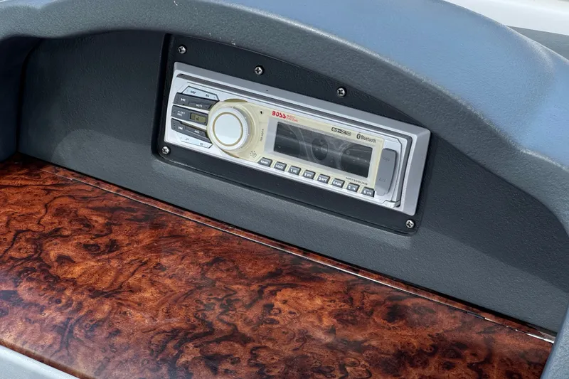 Slide: The Image of 2006 Four Winns 200 Horizon dashboard with wood grain finish and stereo system. - 22