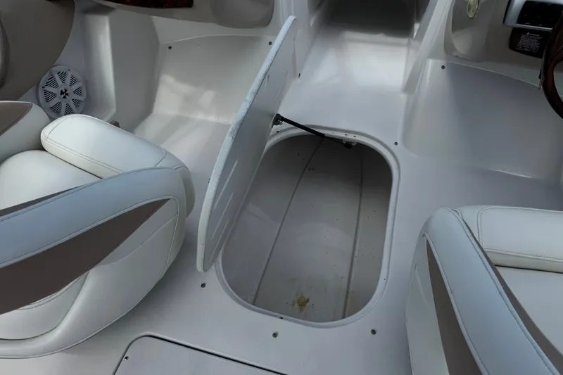 Slide: The Image of 2006 Four Winns 200 Horizon boat interior with open storage compartment and white seating. - 24