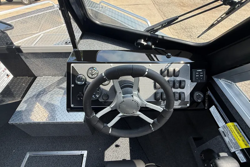 Slide: The Image of 2026 Lund 210 Heavy Gauge boat dashboard with steering wheel and control panel. - 15